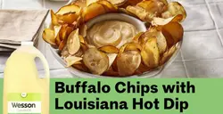 A bowl of chips with a buffalo sauce in the center of the bowl
